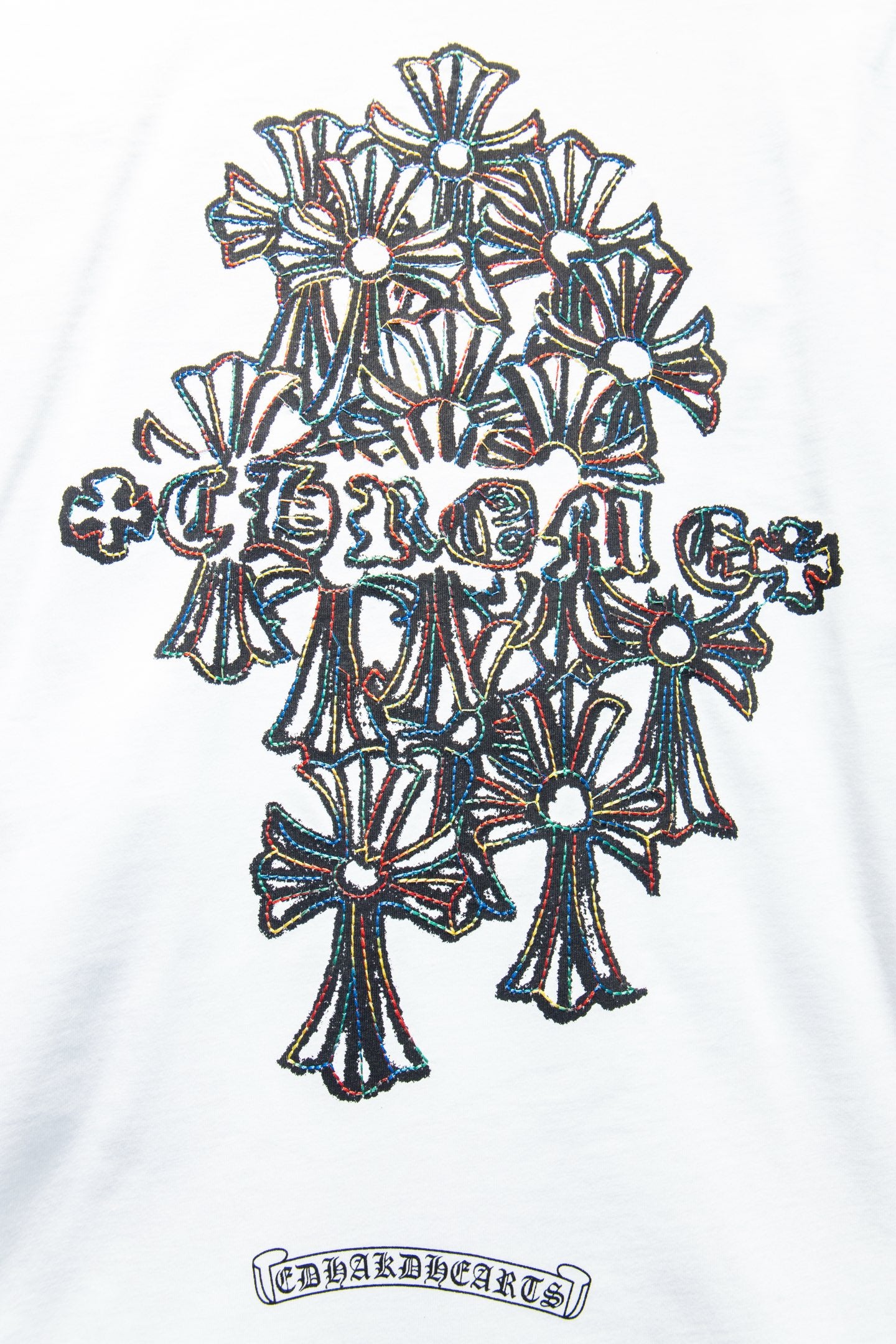 White T-shirt close-up of floral crown graphic and rectangular logo text