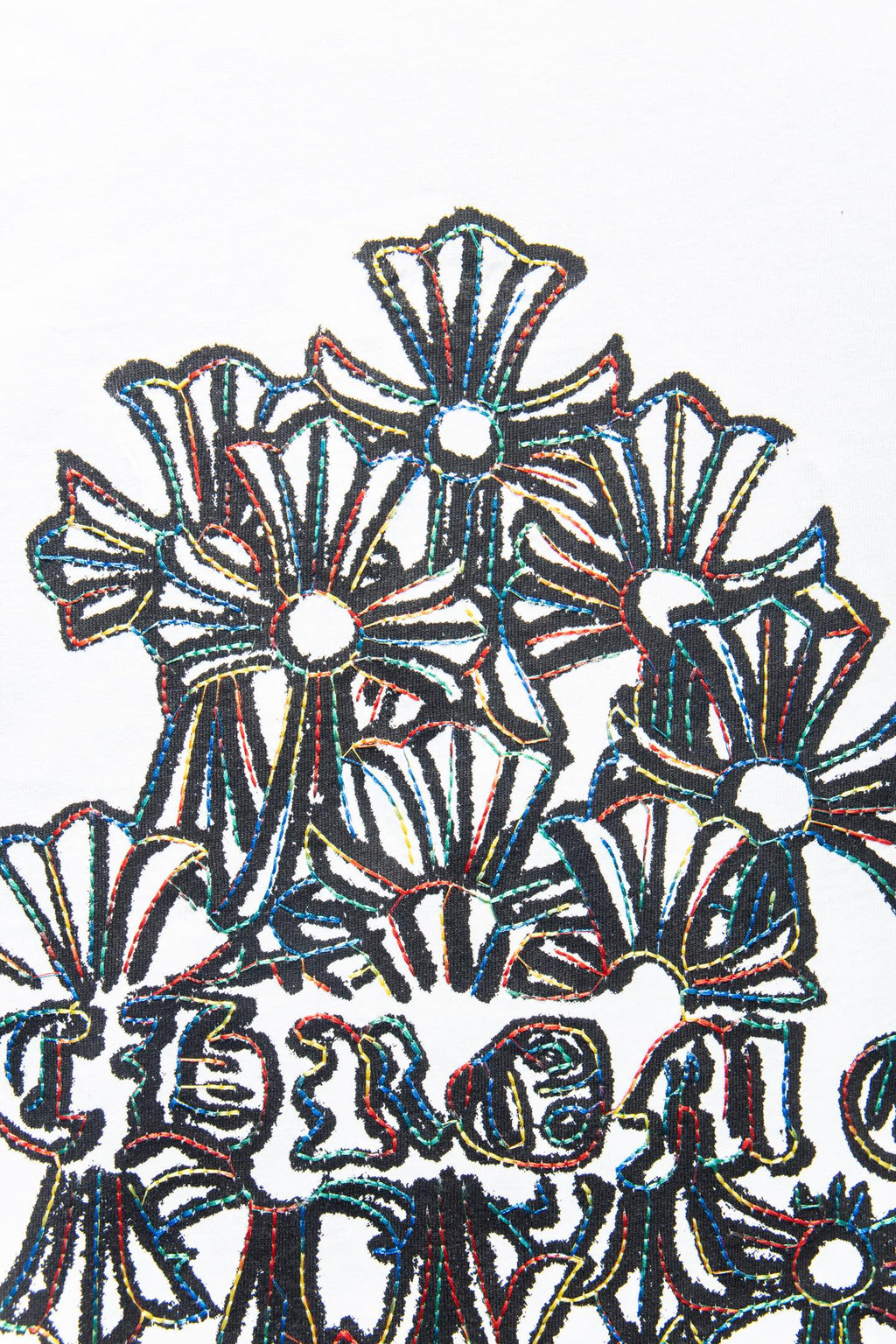 White T-shirt close-up of embroidered floral motifs with dark outline