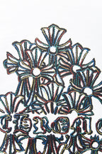 White T-shirt close-up of embroidered floral motifs with dark outline