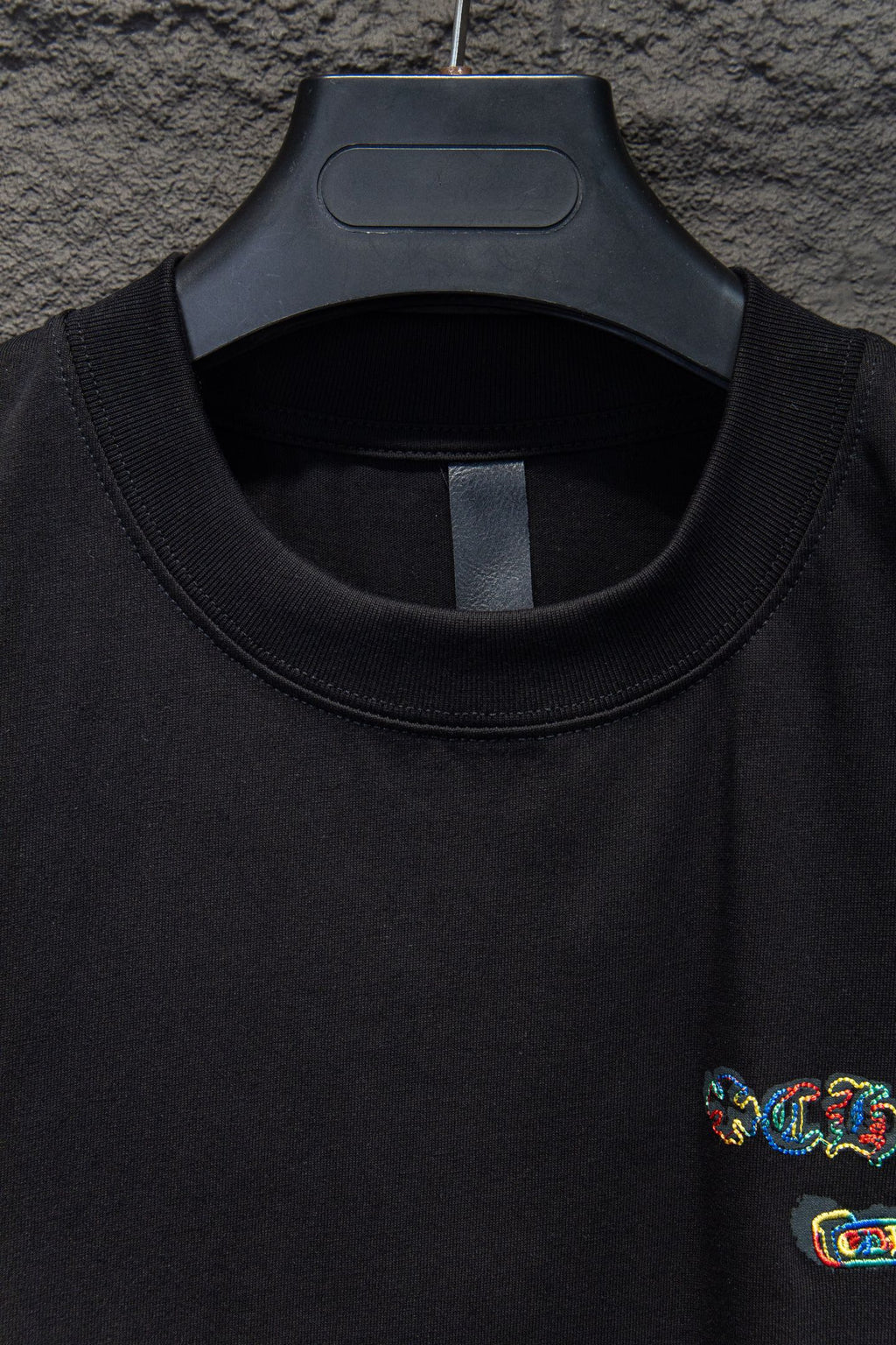 Black crewneck T-shirt neckline with small side chest embroidery