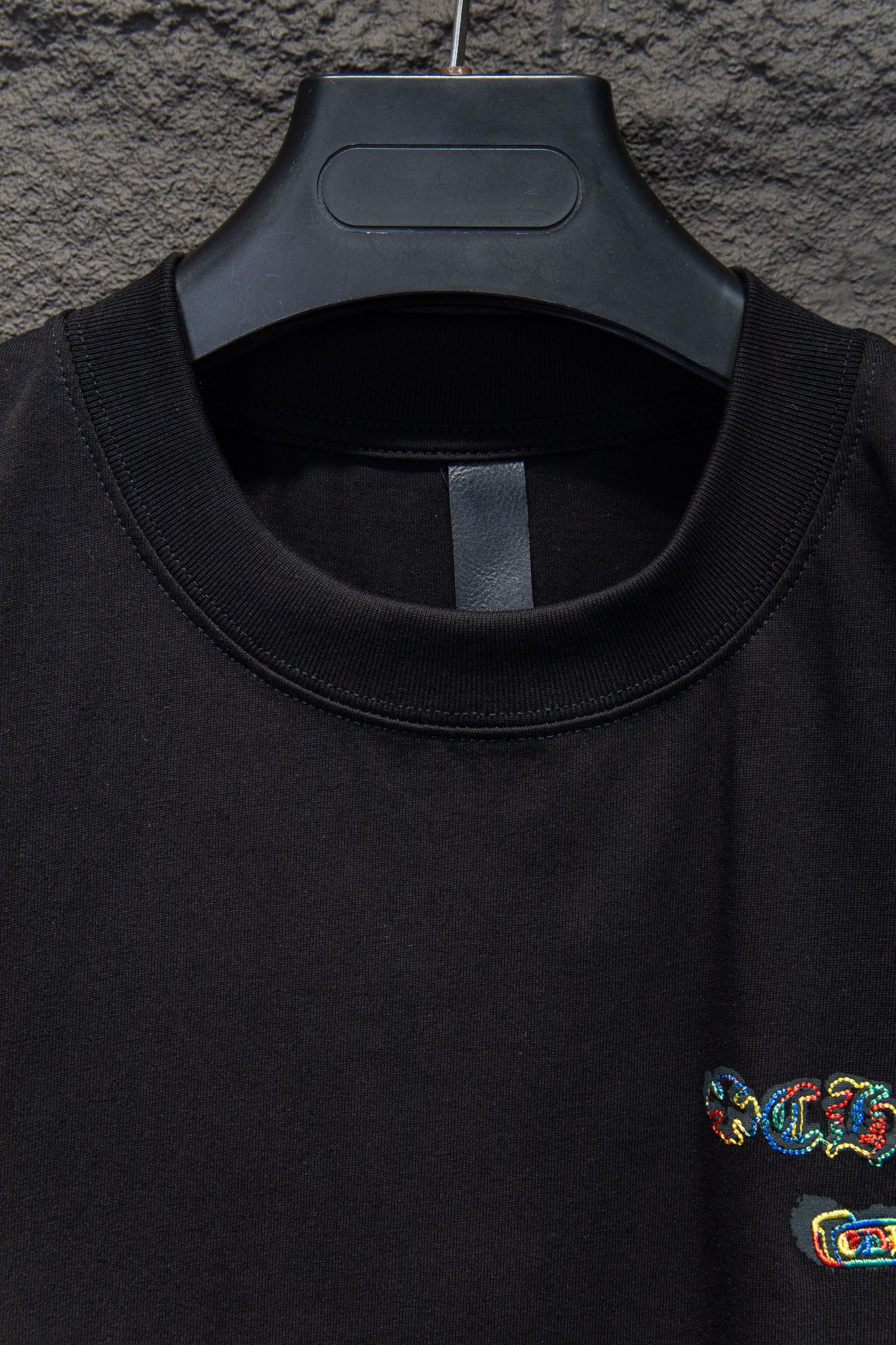 Black crewneck T-shirt neckline with small side chest embroidery