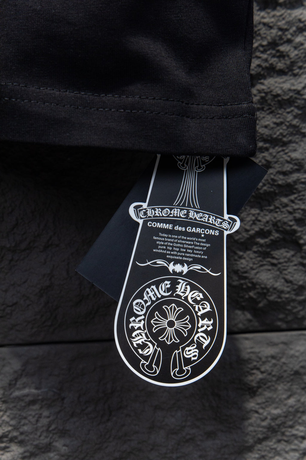 Black short-sleeve T-shirt hem with white hanging brand tags