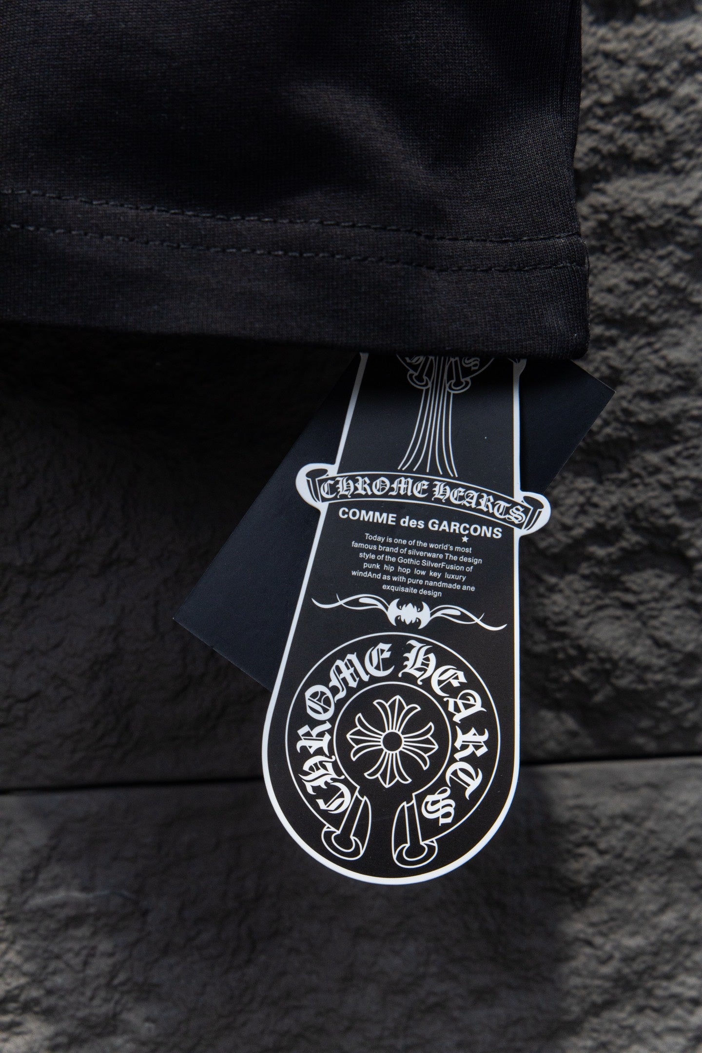 Black short-sleeve T-shirt hem with white hanging brand tags
