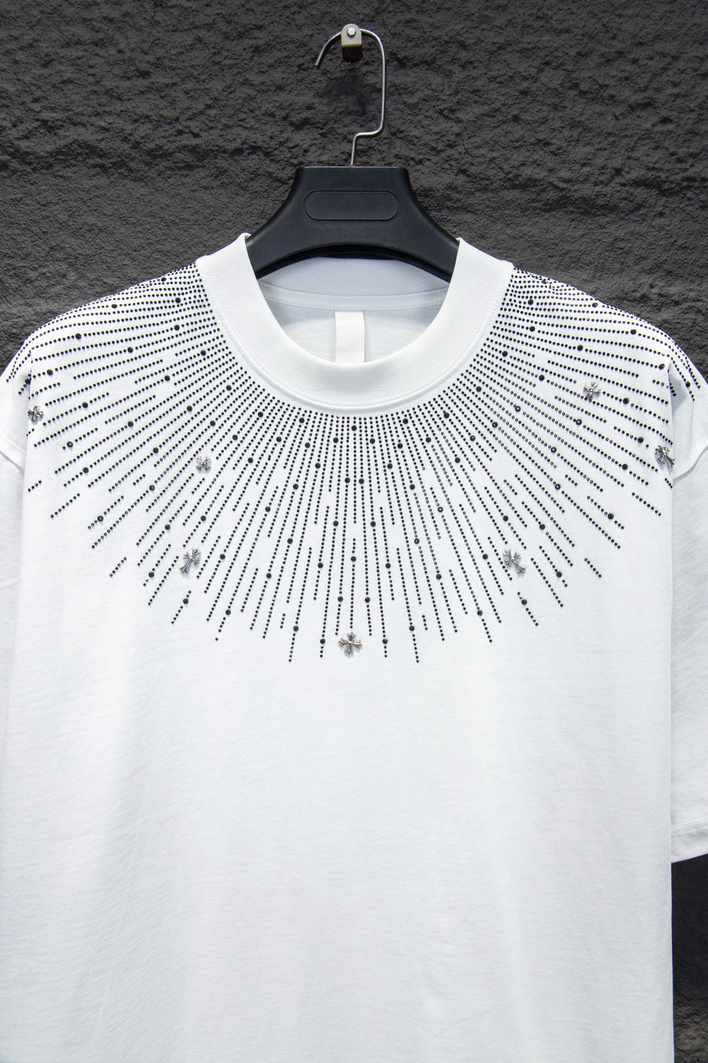 White short-sleeve T-shirt with studded sunburst detail and cross charm accents