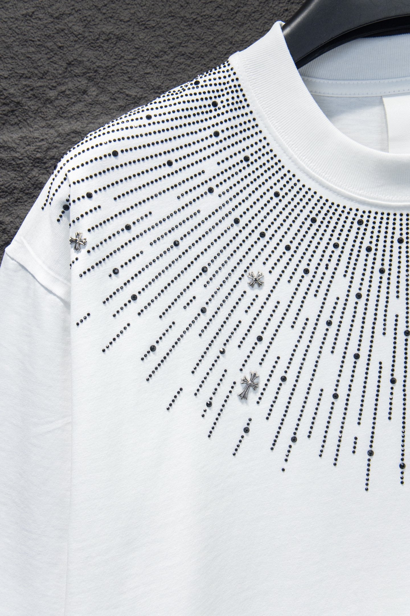 Embellished T-shirt sleeve with studded dot pattern and cross charms