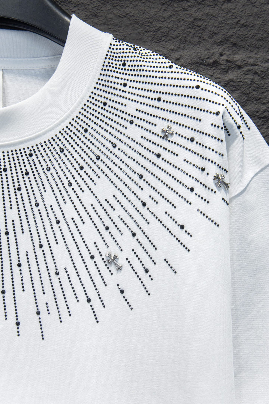 Embellished white T-shirt with studded lines and small cross charm accents