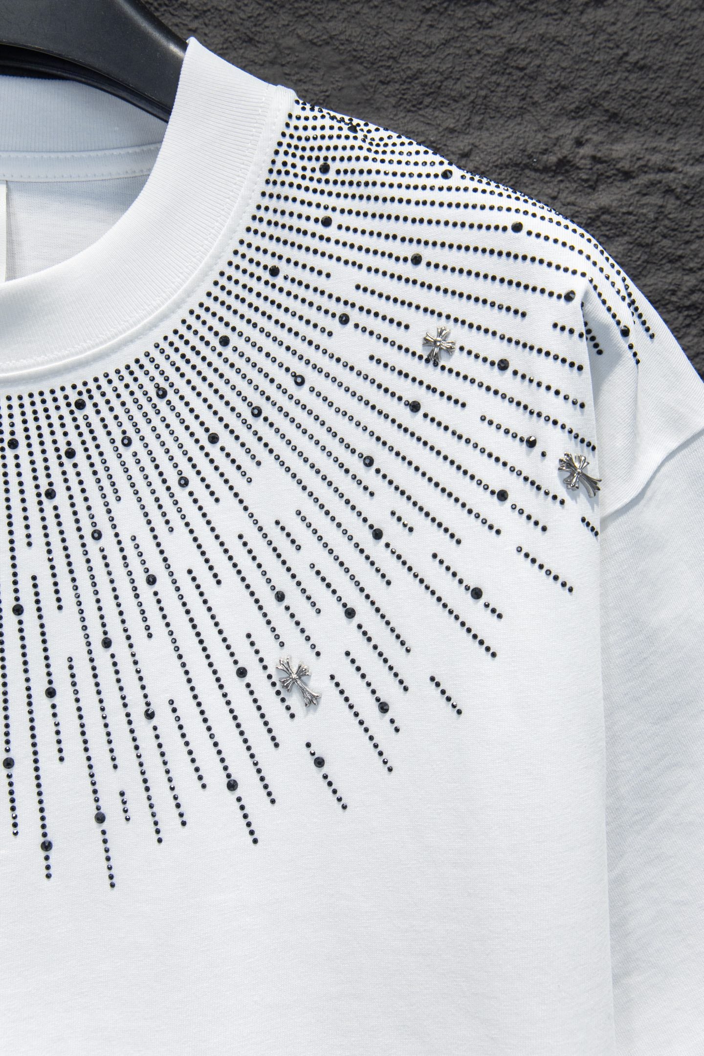 Embellished white T-shirt with studded lines and small cross charm accents