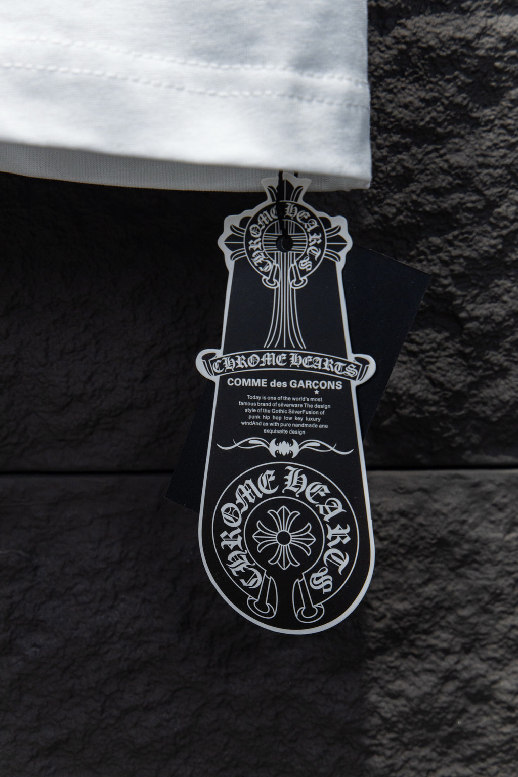Black and white clothing tag attached to the T-shirt hem