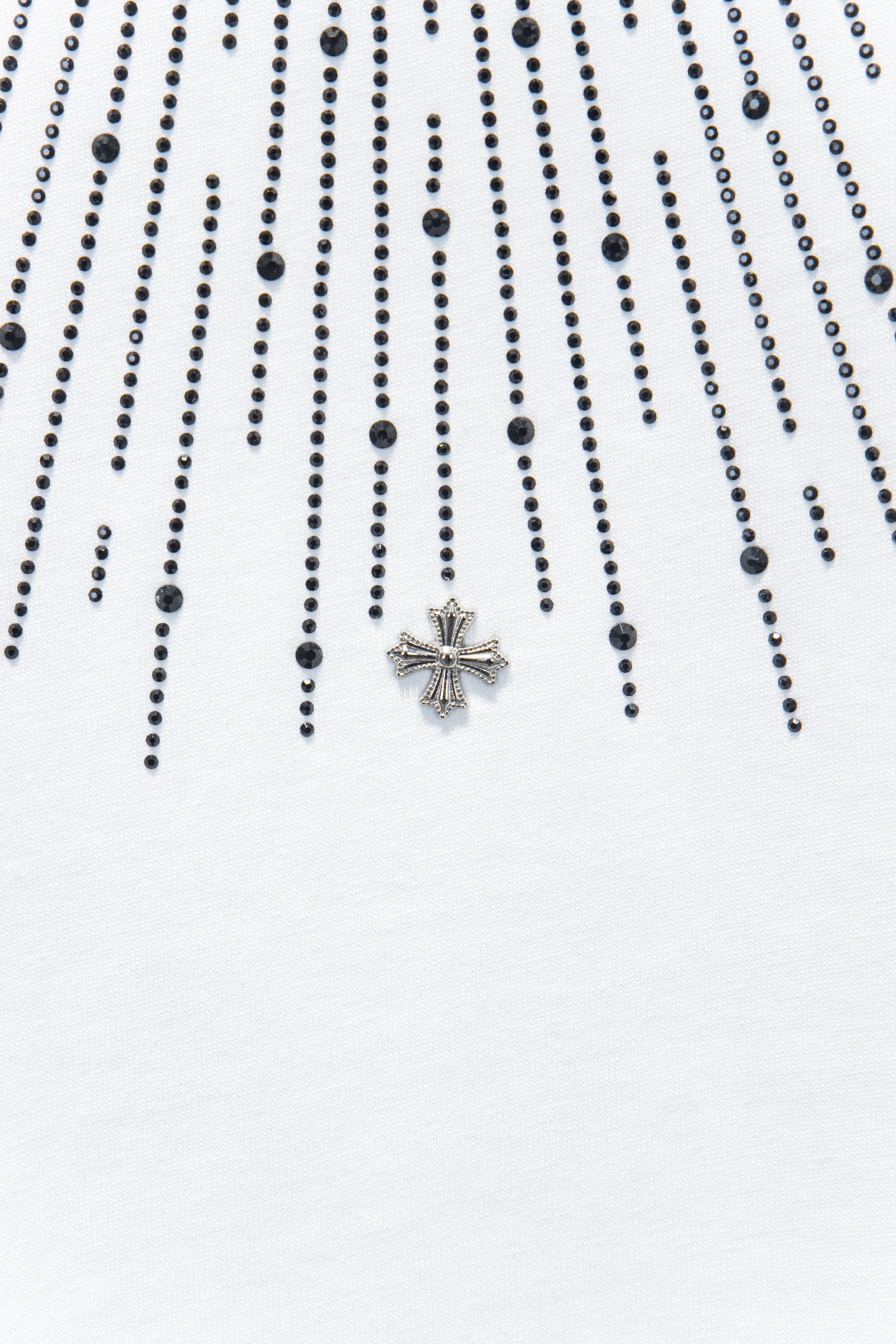Embellished chest detail with star-shaped cross charm on a white T-shirt