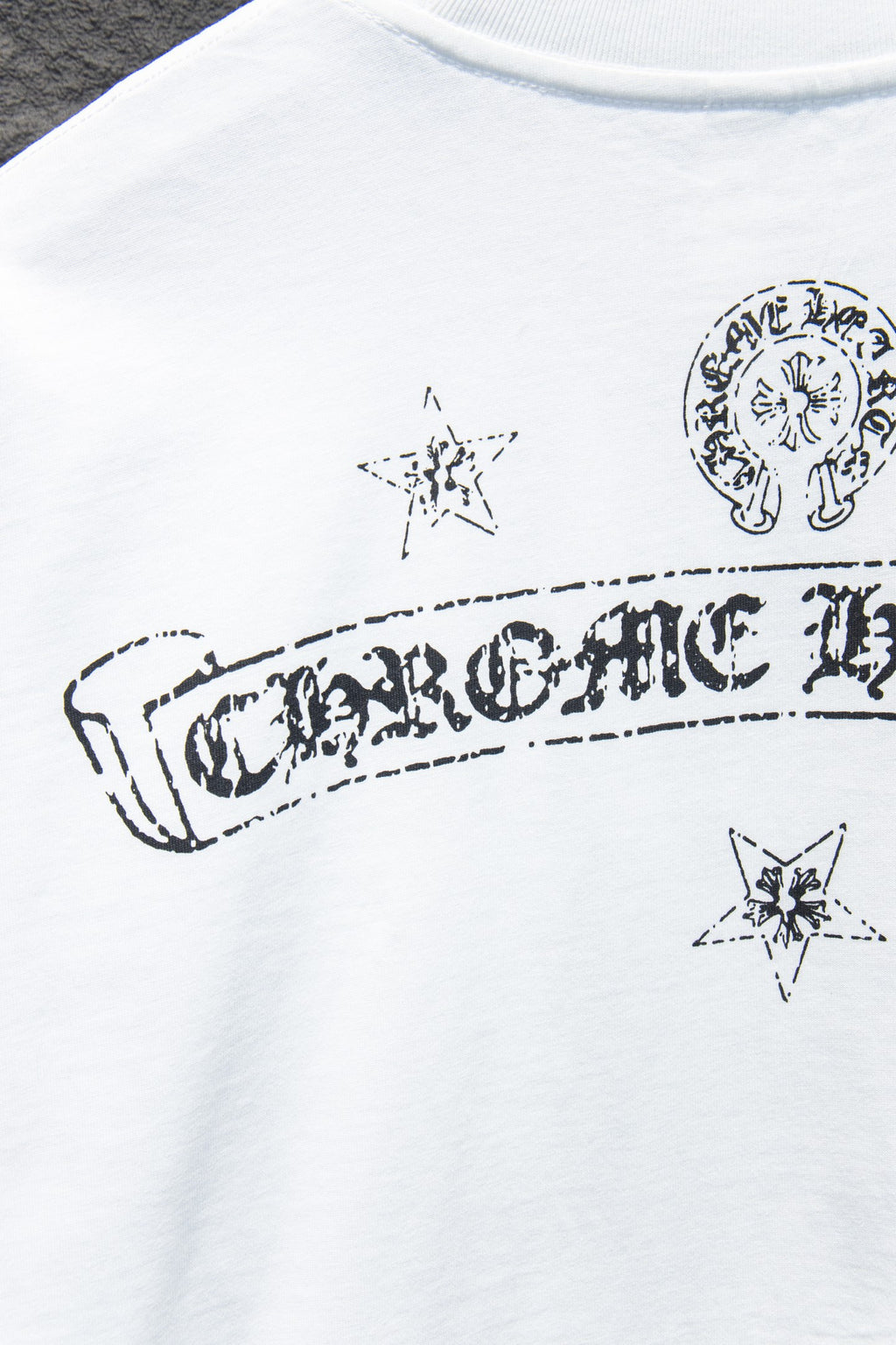 White crewneck T-shirt with large banner graphic and small star icons