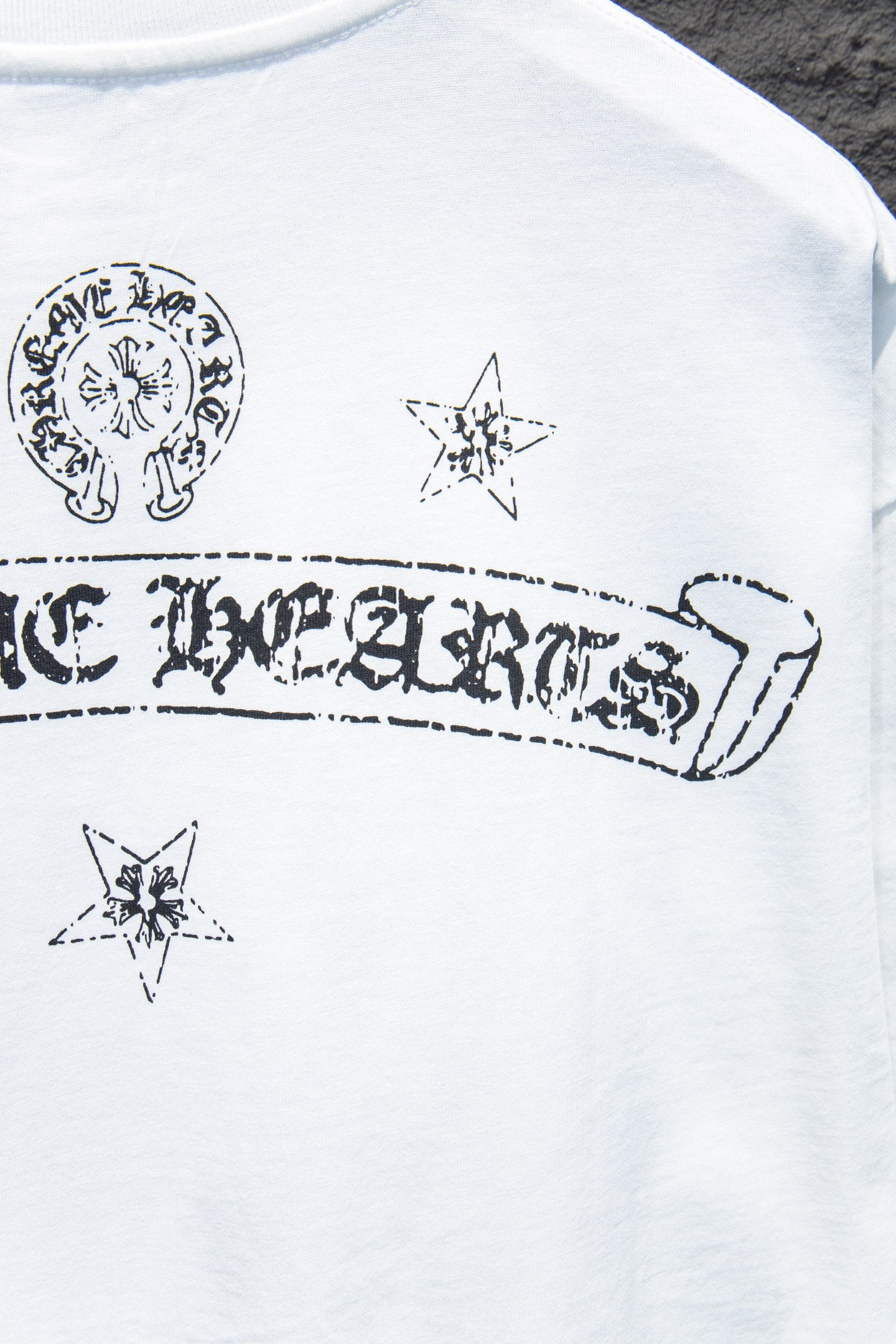 White crewneck T-shirt with circular crest and star graphics on chest