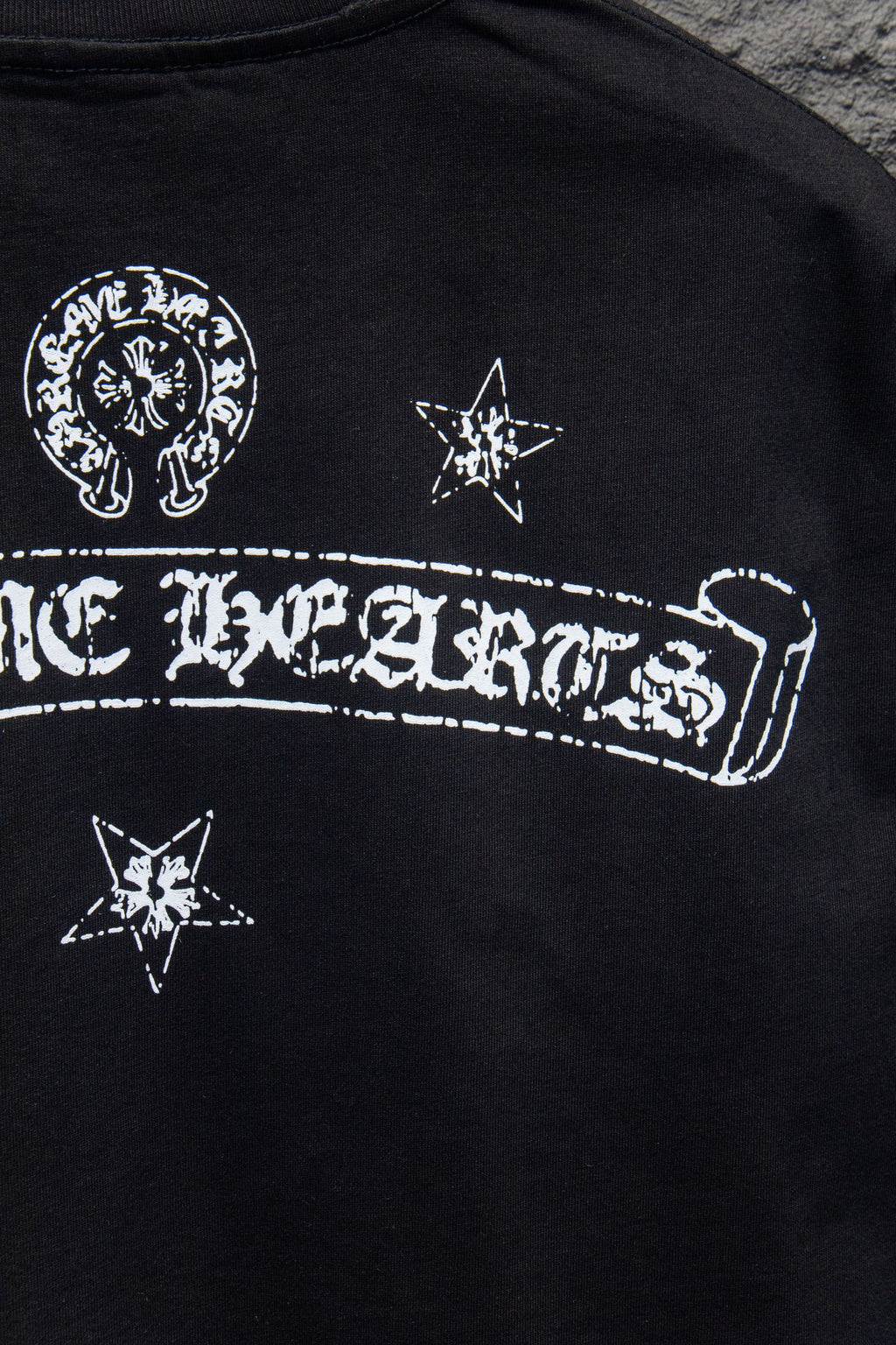 Black T-shirt with large arched wordmark graphic and star icons