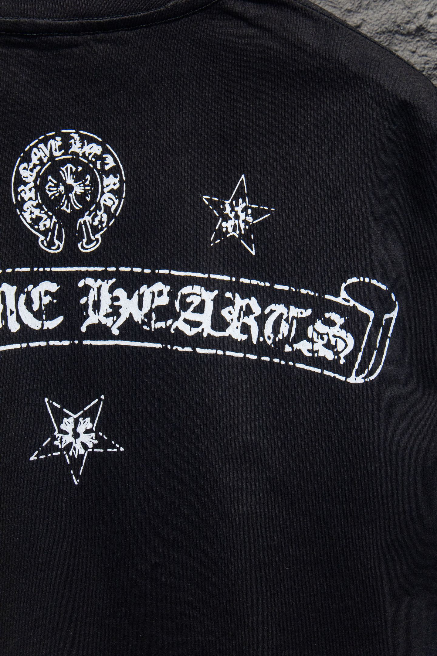 Black T-shirt with large arched wordmark graphic and star icons