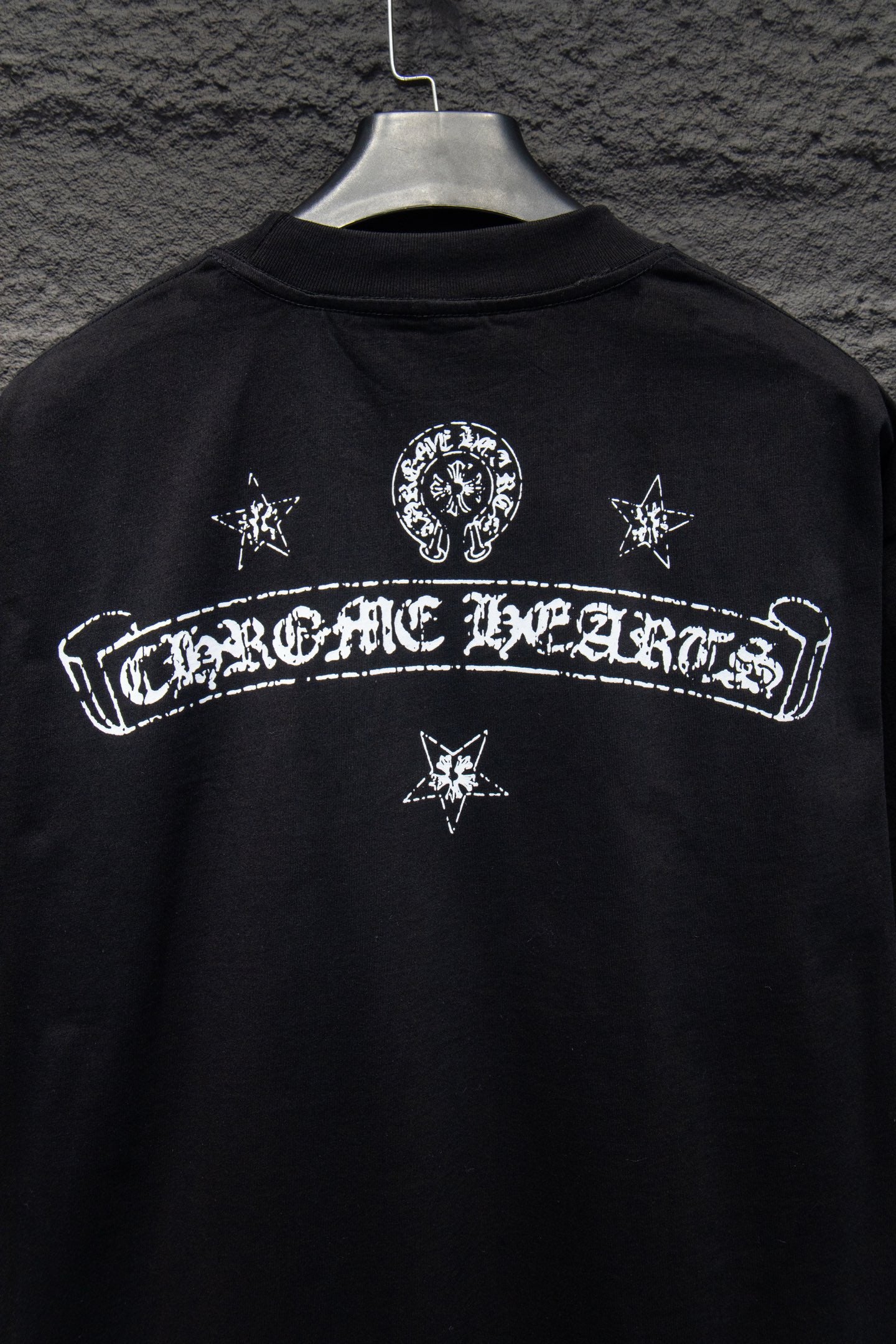 Black T-shirt back with centered arch logo and star icons