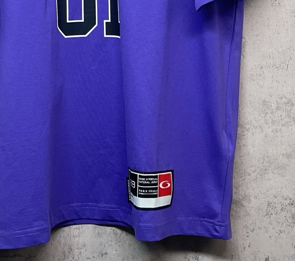 Purple T-shirt hem with red-and-white label patch