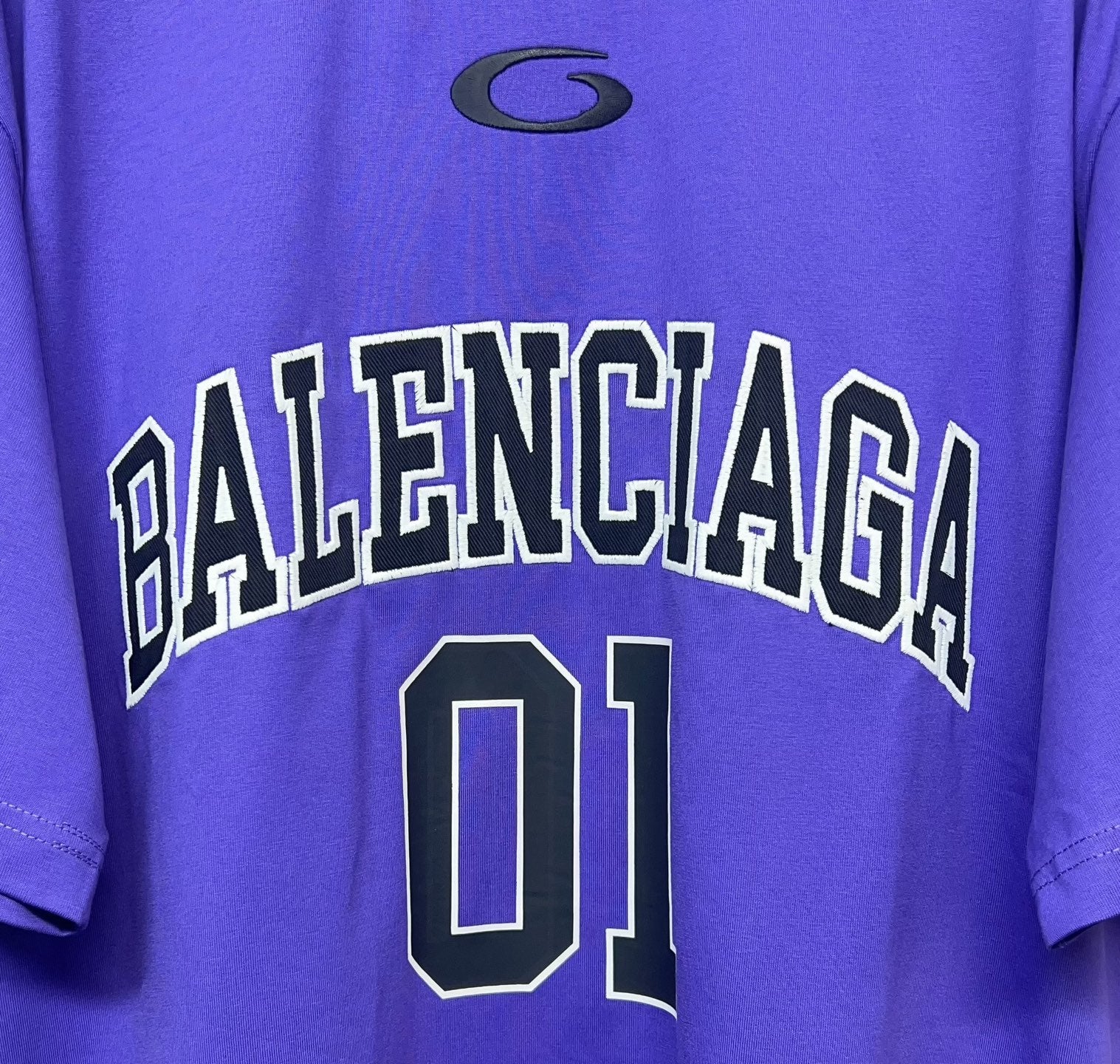 Purple T-shirt close-up of BALENCIAGA lettering and '01' number