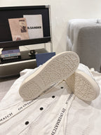 White Dior sneakers outsole view with patterned tread and side branding