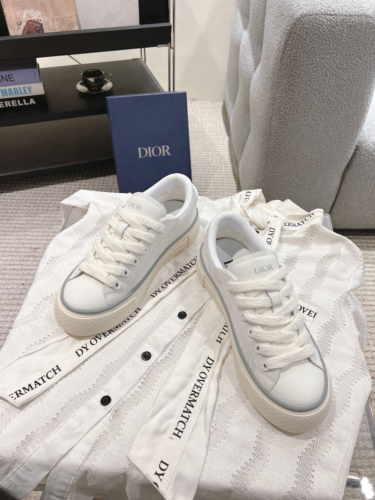 White Dior low-top sneakers with lace-up front, on dust bag and box