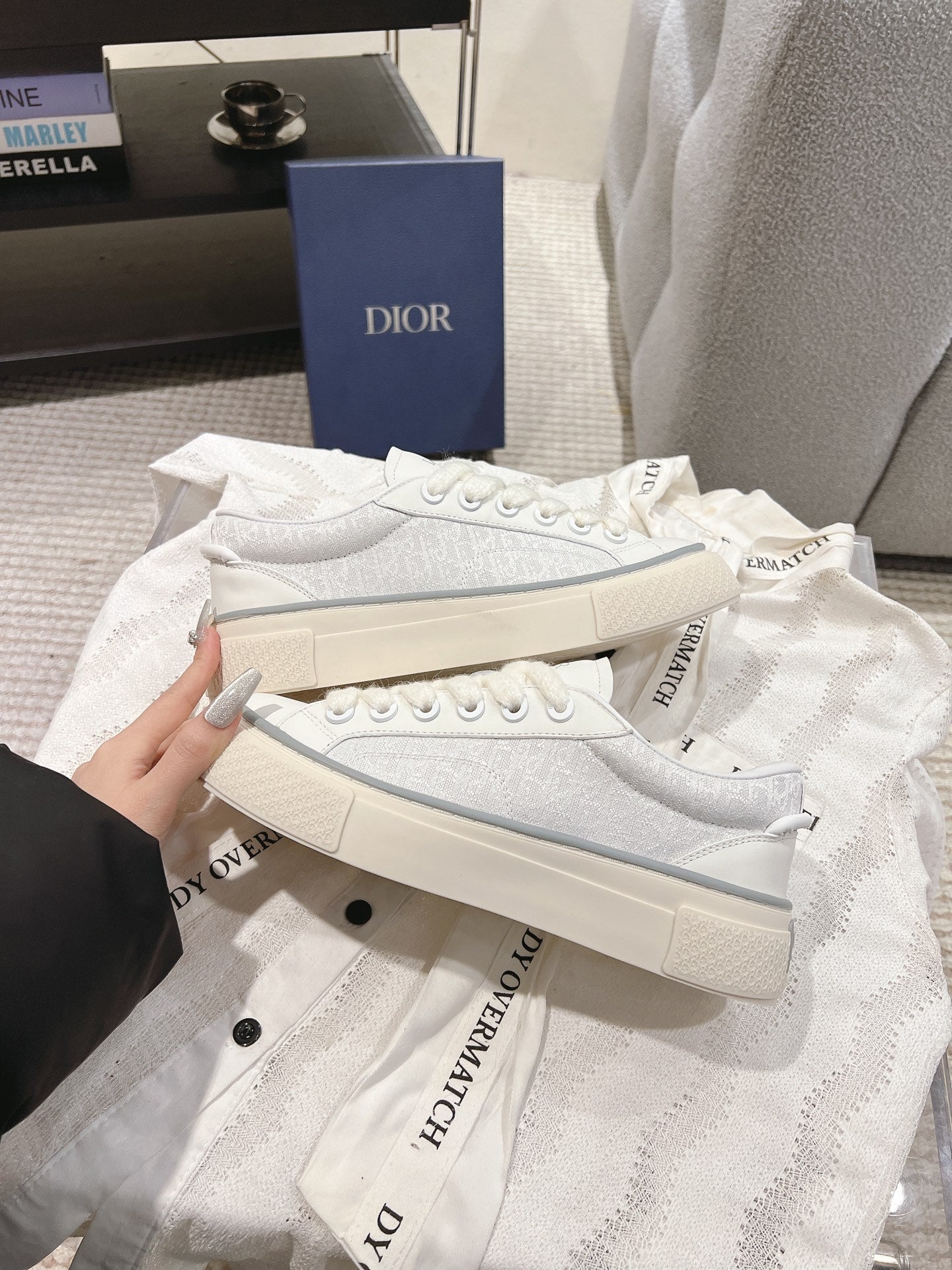 White Dior low-top sneakers side view with ridged sole and lace eyelets