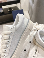 White Dior low-top sneaker side view with perforated-texture fabric panel