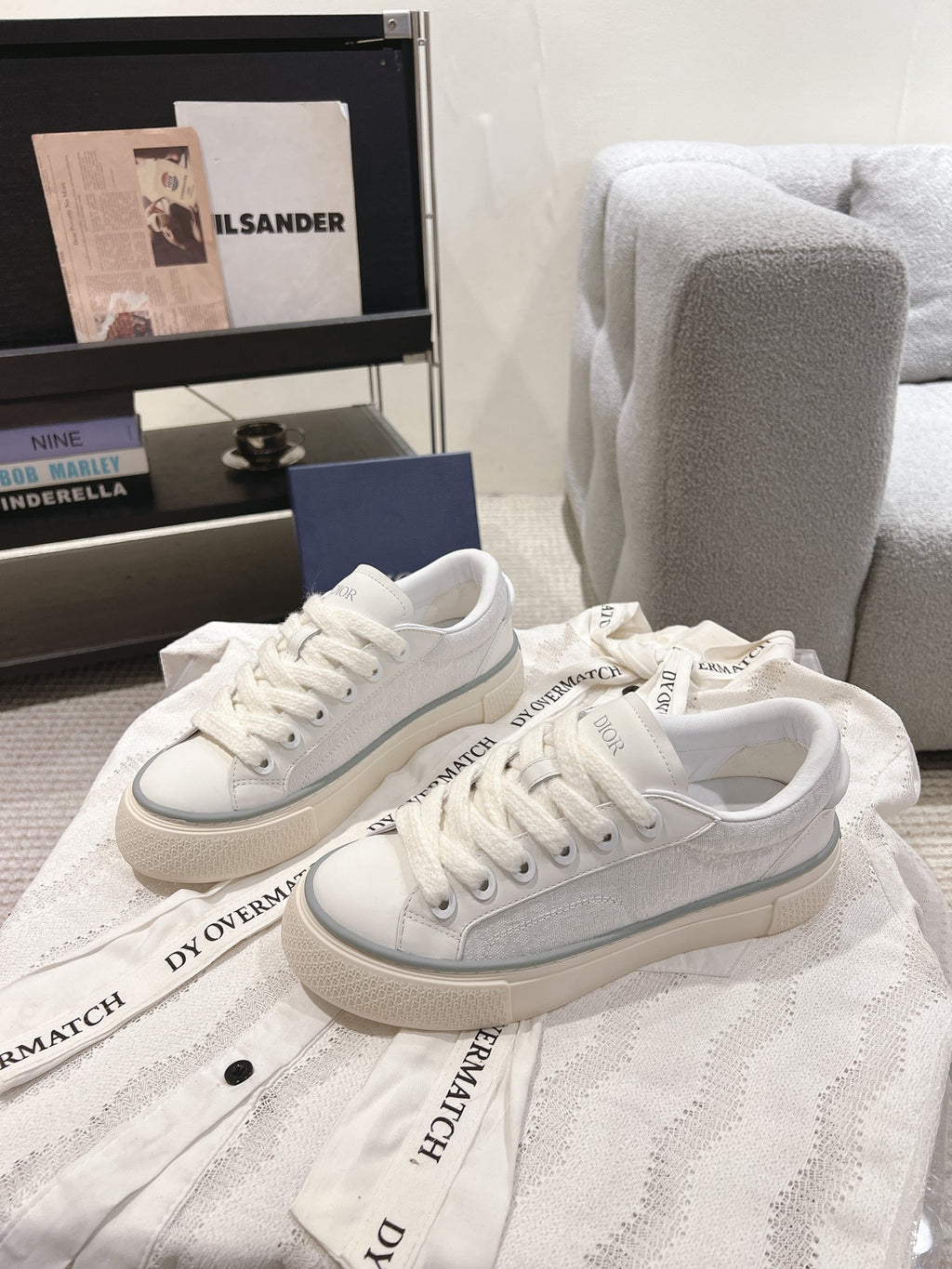 White Dior low-top sneakers on display, lace-up with textured sidewall