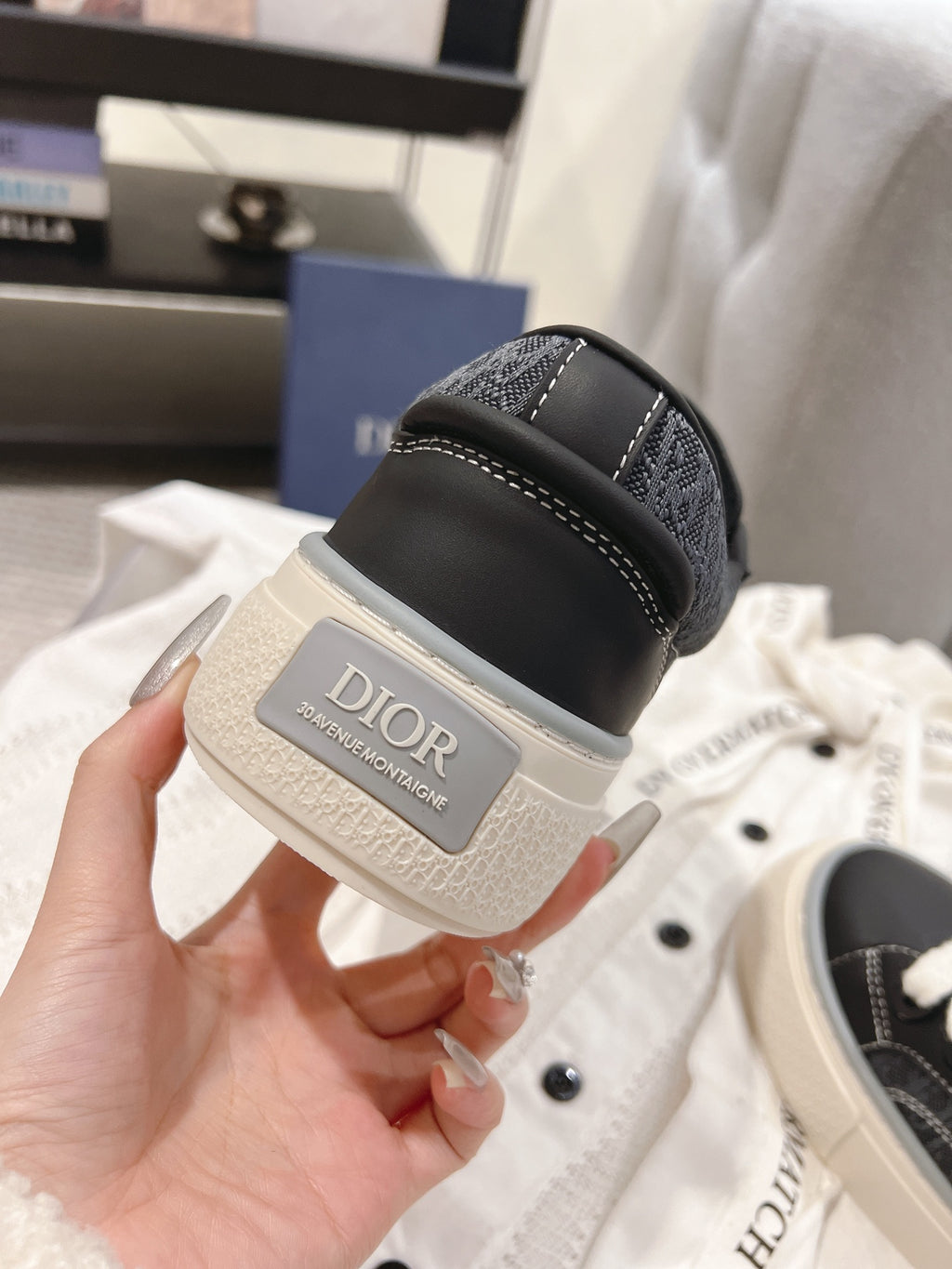Unisex sneaker heel close-up in dark gray with off-white sole and Dior label patch