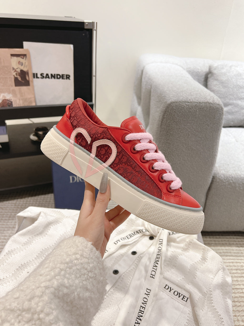 Red Dior low-top sneaker with embossed heart logo and pink laces