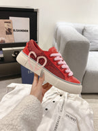 Red Dior low-top sneaker with embossed heart logo and pink laces