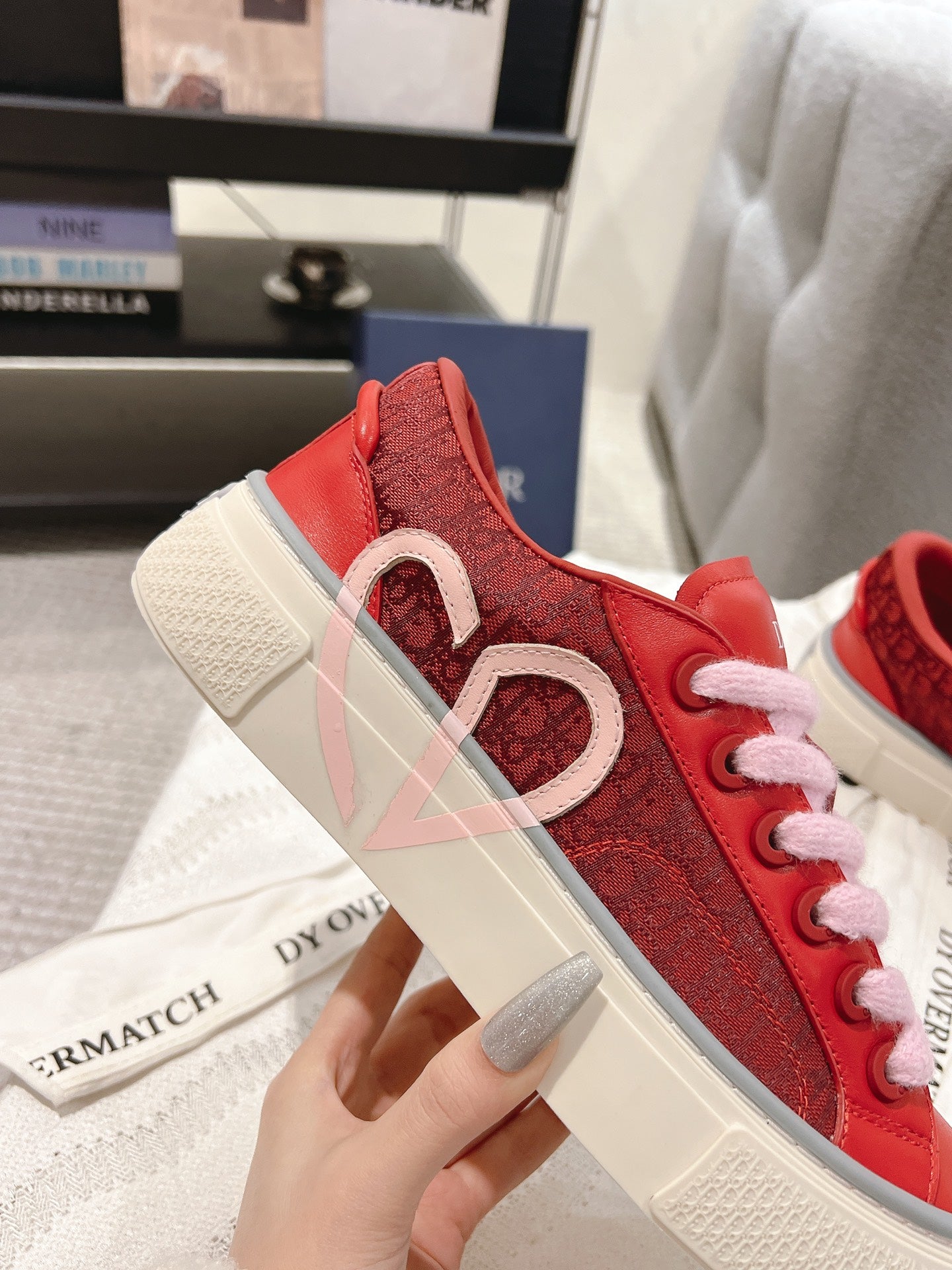 Red Dior low-top sneaker close-up with heart motif and pink laces