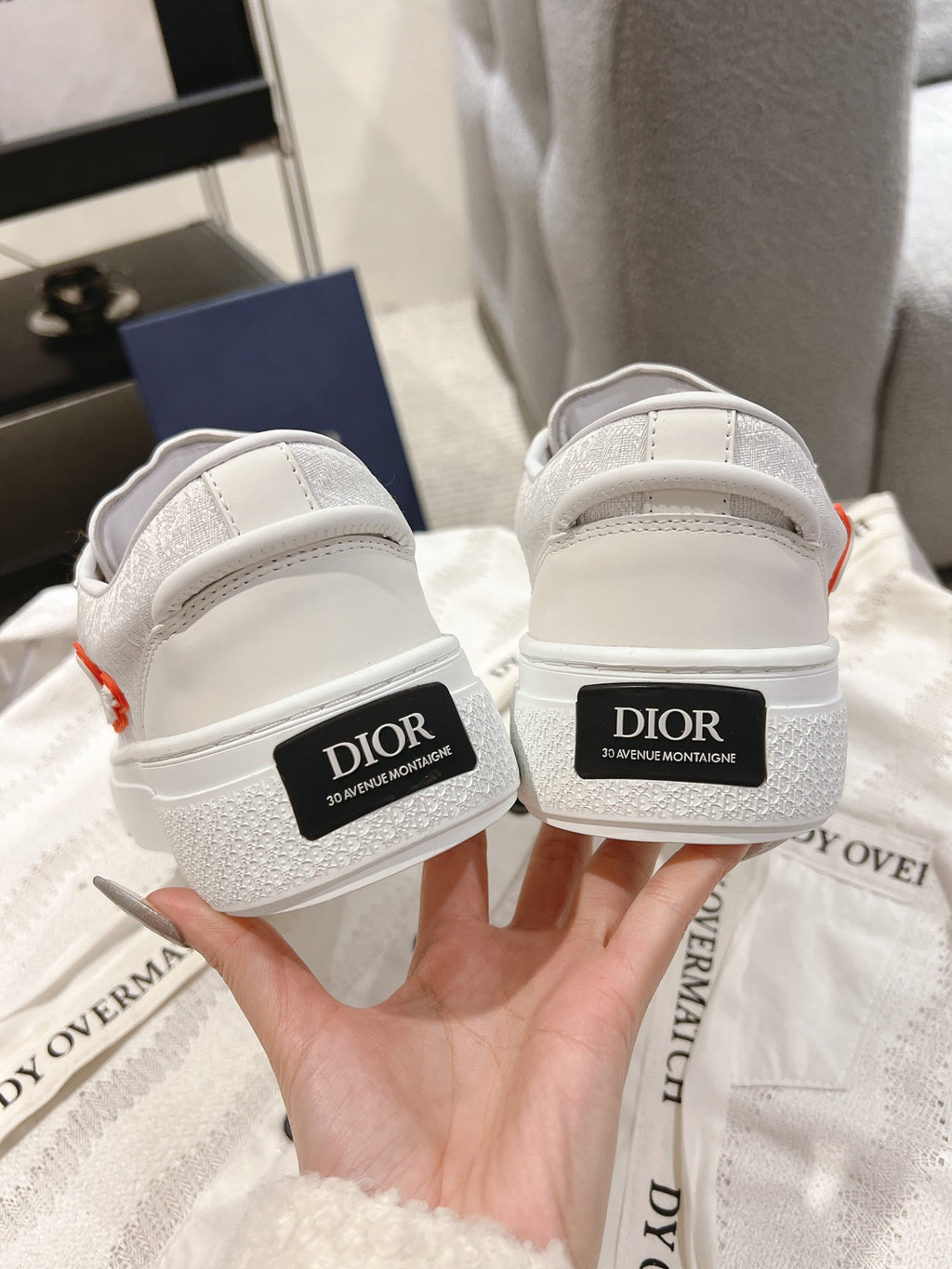 White Dior sneakers with branding on the heel and back panels