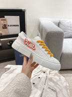 White Dior low-top sneaker with mustard laces and red heart logo