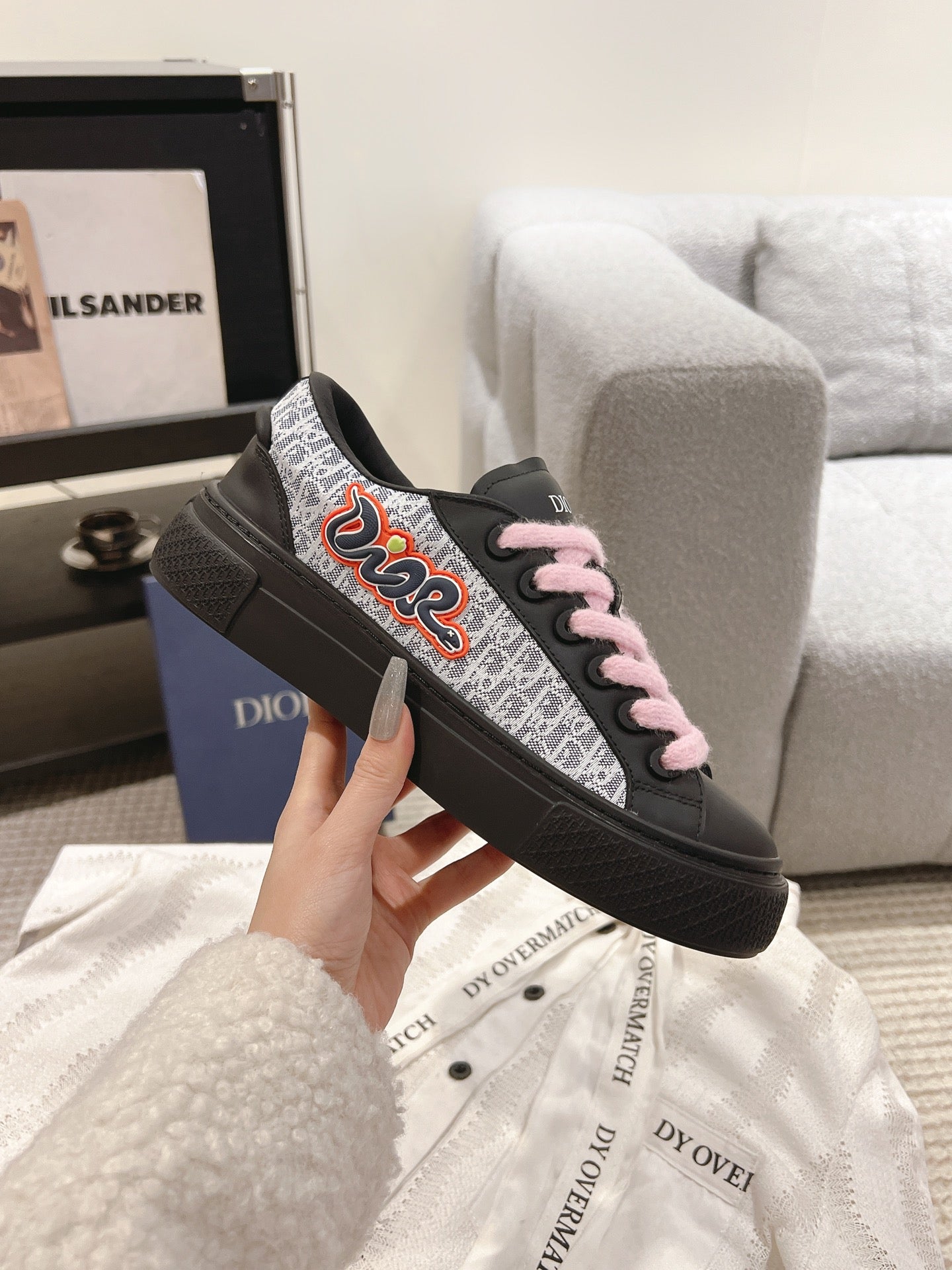 Black low-top sneaker with pink laces and sporty flame-style logo on side