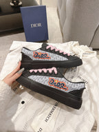 Black low-top sneakers with pink laces and colorful side graphic on patterned panels