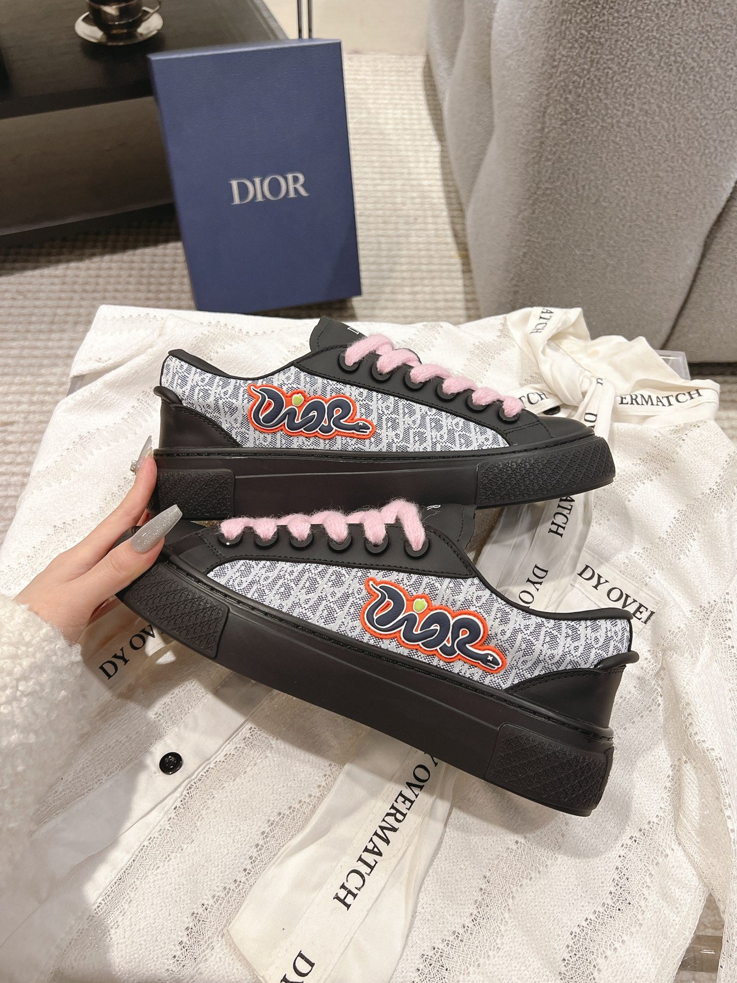 Black low-top sneakers with pink laces and colorful side graphic on patterned panels