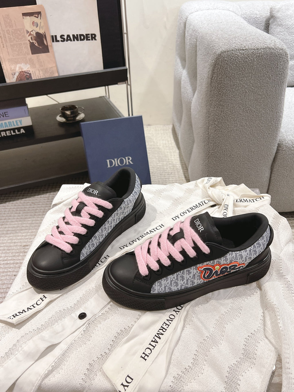 Pair of black low-top sneakers with pink laces and patterned side panels