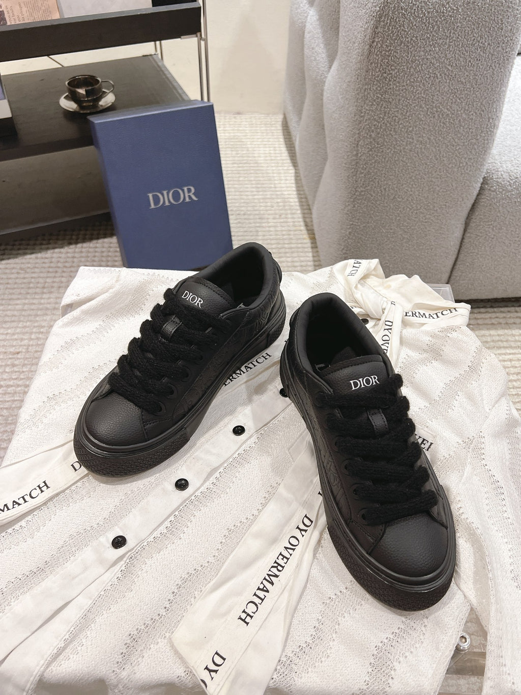 Dior unisex black lace-up sneakers on a white cloth with Dior branding on uppers