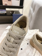 Unisex sneaker detail: light gray-beige lace-up with Dior logo on the tongue