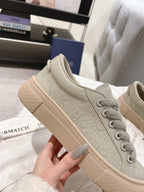 Unisex low-top sneaker in light gray-beige with embossed pattern and lace-up