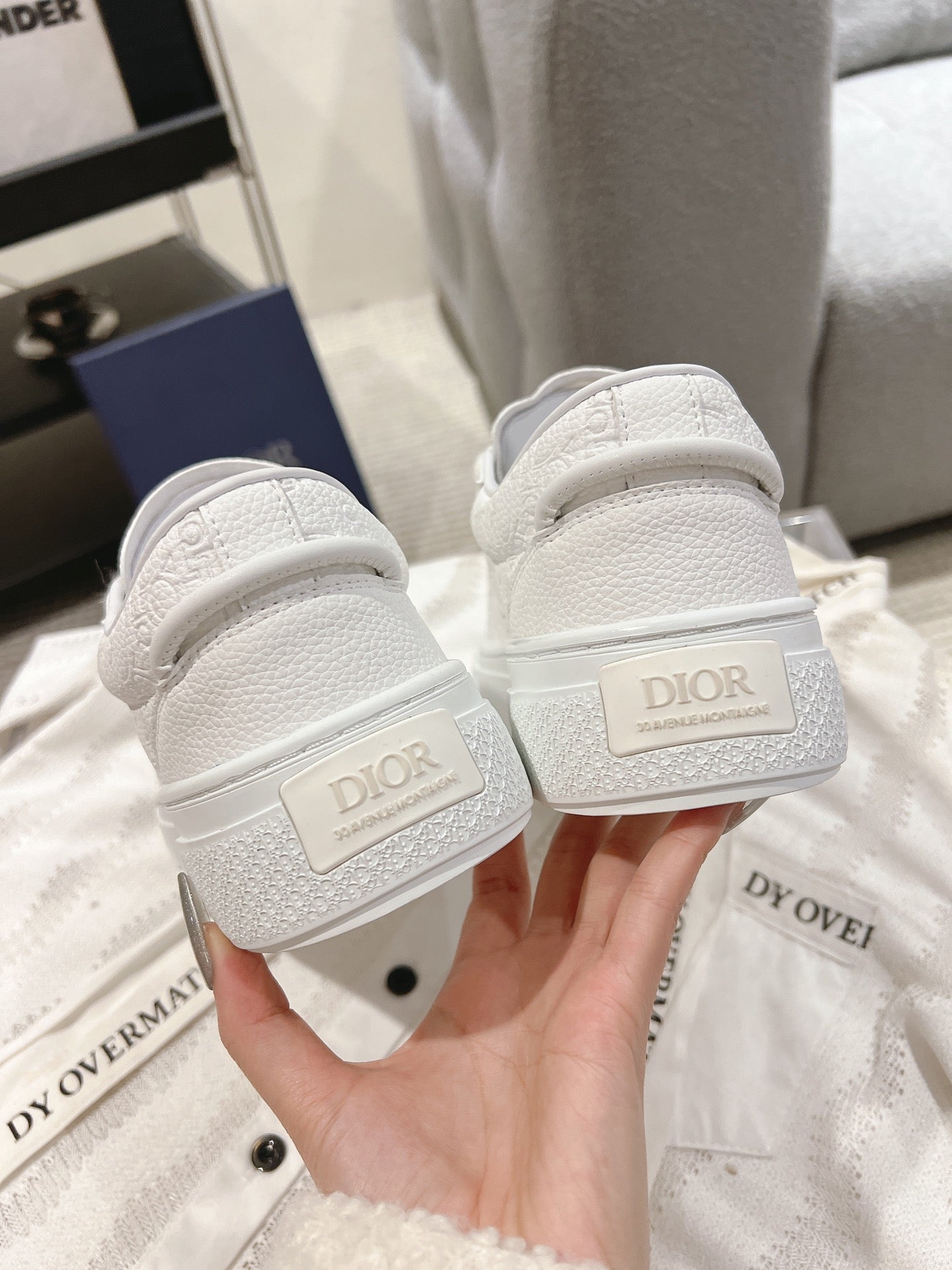 White sneakers showing heel tabs with DIOR logo and cushioned collar