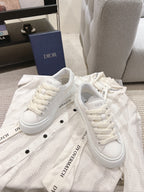 White lace-up low-top sneakers with embossed texture and logo detail