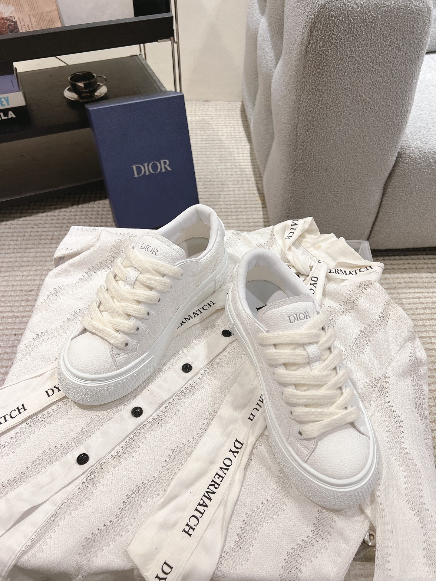 White lace-up low-top sneakers with embossed texture and logo detail