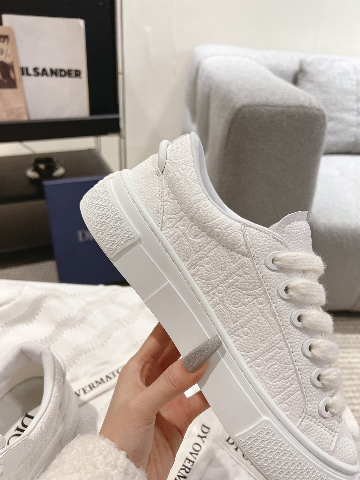 White low-top sneaker with lace-up front and textured side panels