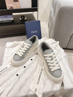 White low-top sneakers with gray collar and white laces, DIOR branding on tongue