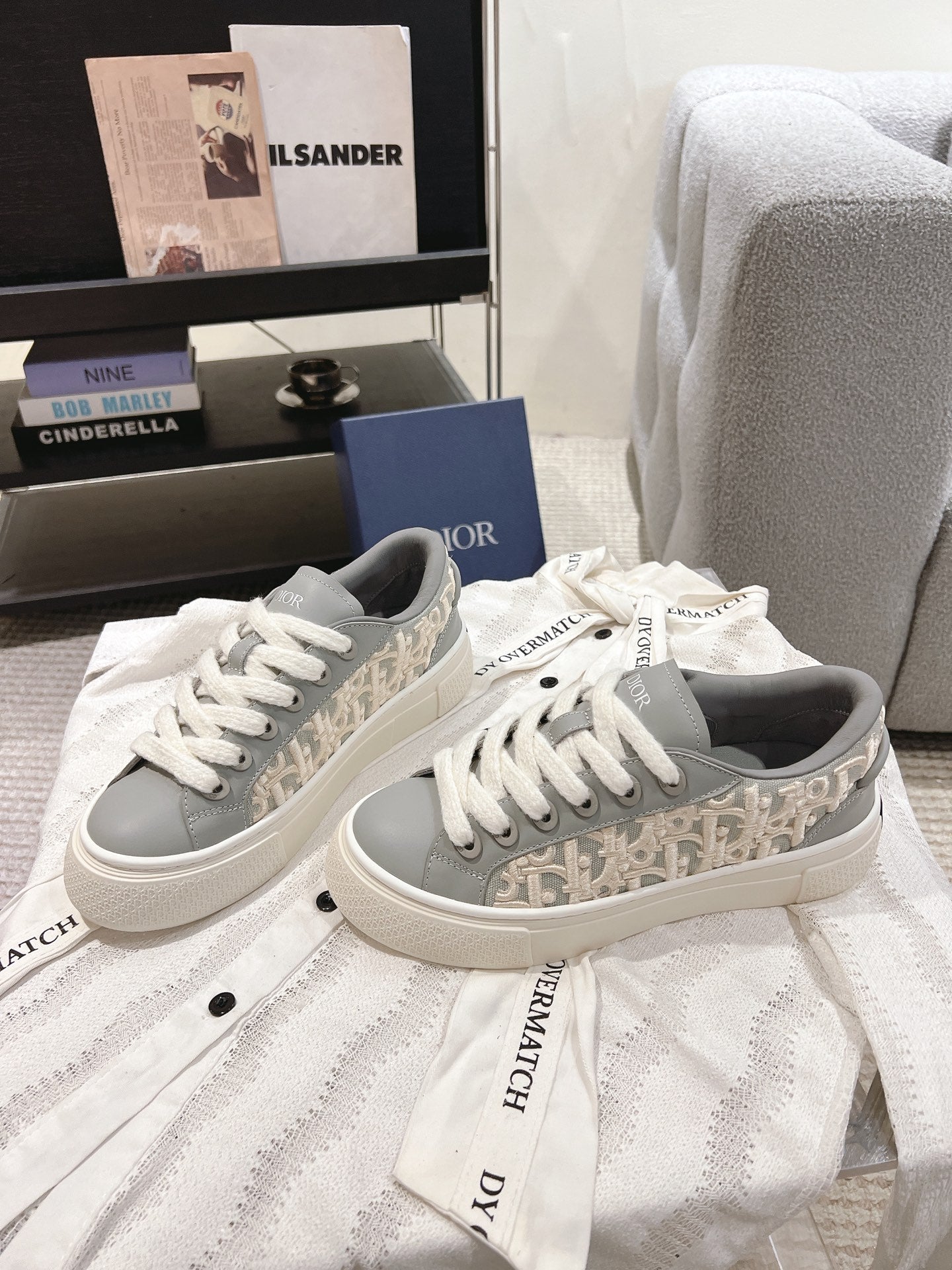 Pair of white low-top lace-up sneakers with gray trims and DIOR on tongues