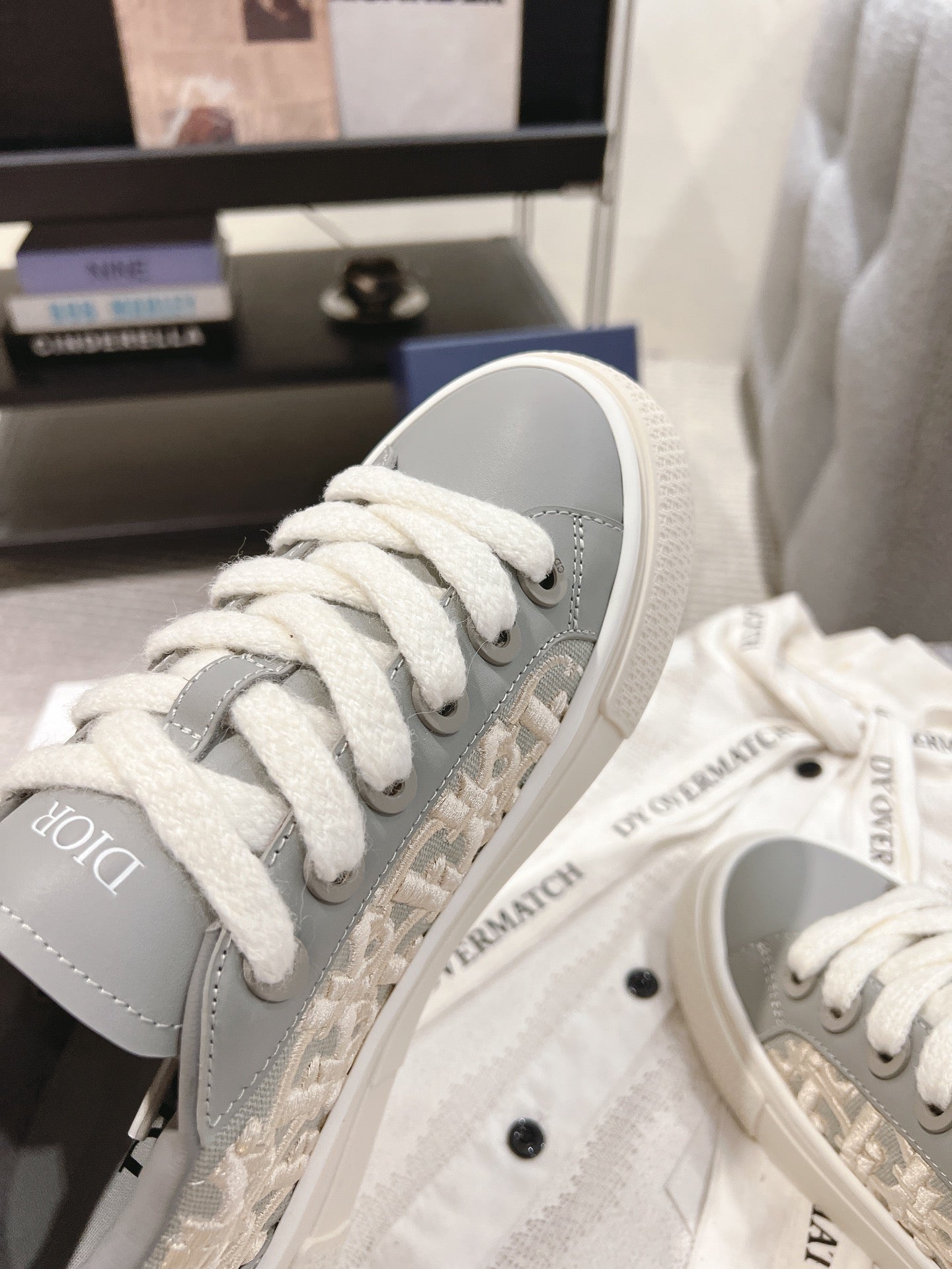 Gray Dior monogram sneaker side view with white laces and white midsole