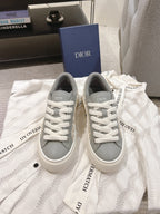 White low-top sneakers with gray collar and white lace-up, DIOR on tongue