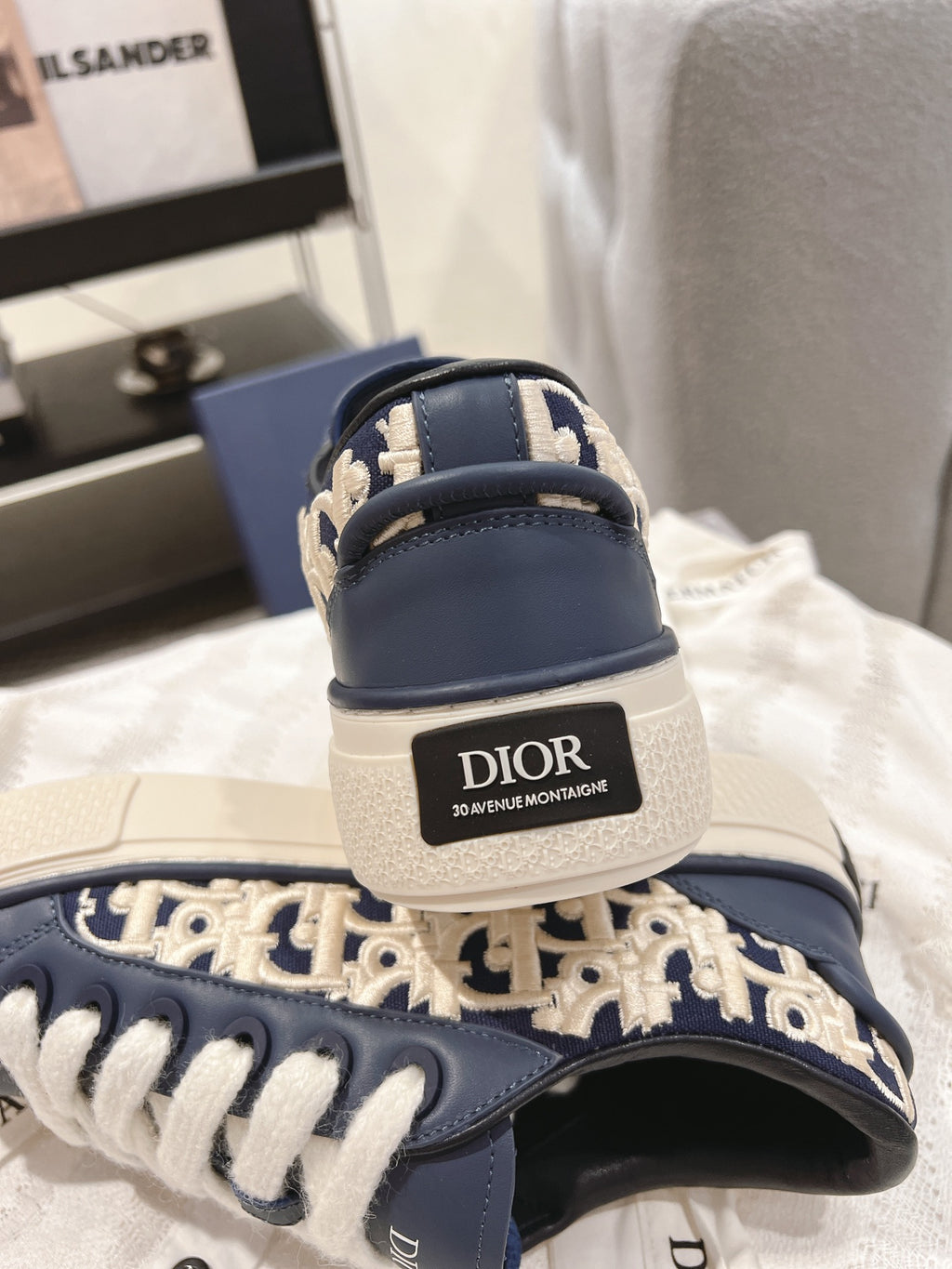 Navy sneakers with white laces and a Dior logo heel patch