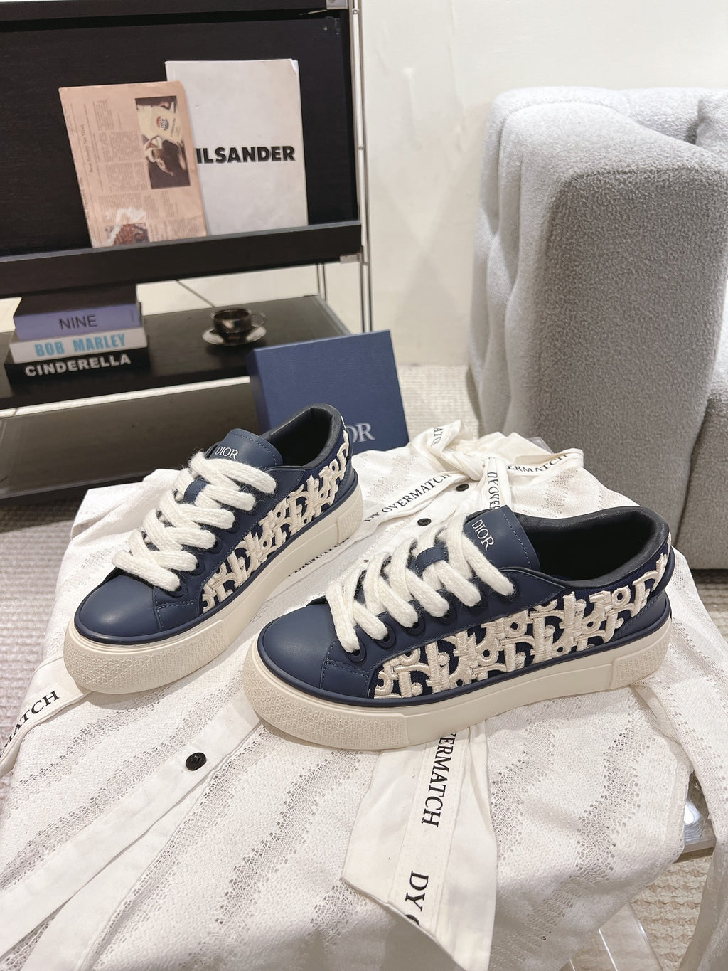 Pair of navy low-top sneakers with white laces, patterned side trim, and chunky sole