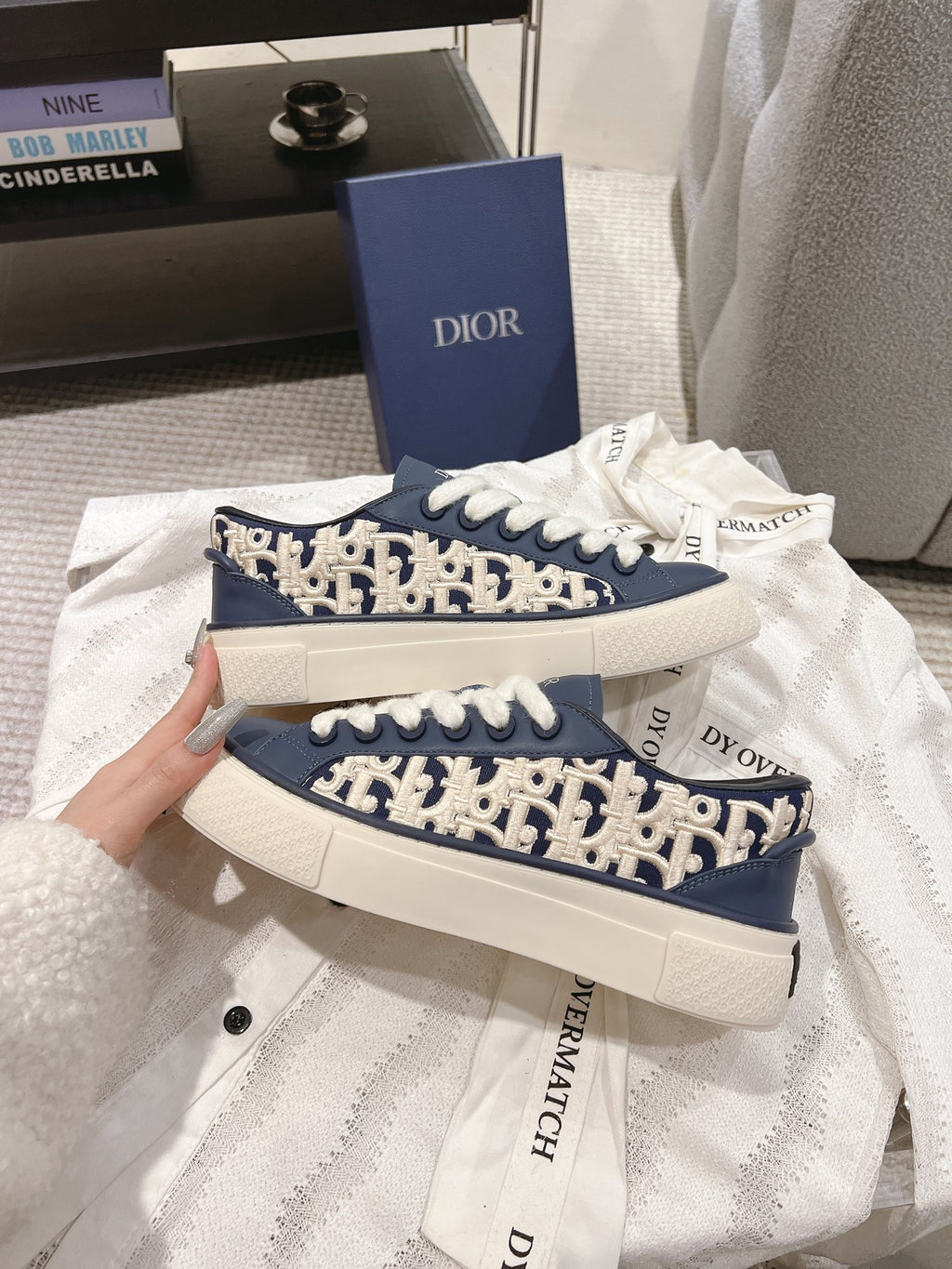 Stacked navy and white sneakers with white laces and logo-pattern side panels