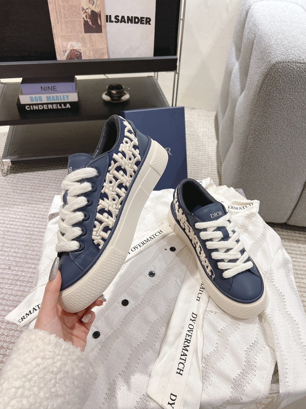 Navy low-top sneakers with white laces, off-white sole, and logo panel detail
